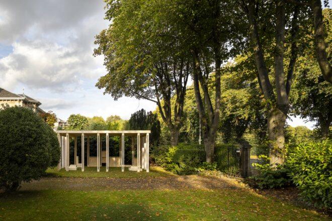 a green outdoor space with a wooden, box-like structure set up