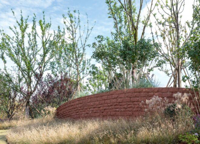 red brick wall surrounded by native plants