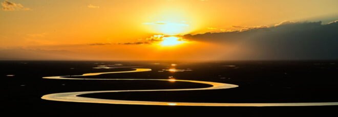 sun setting over a river