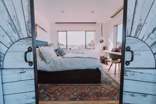 two ornate doors opening up to a large bedroom