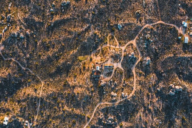 aerial shot of dirt roads leading up to tiny home retreat