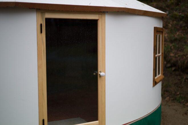 wooden door inside of rounded yurt