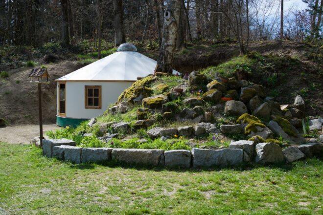 bright white yurt behind green knoll
