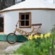 bicycle leaning up against a white yurt