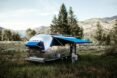 shiny airstream trailer with blue awnings