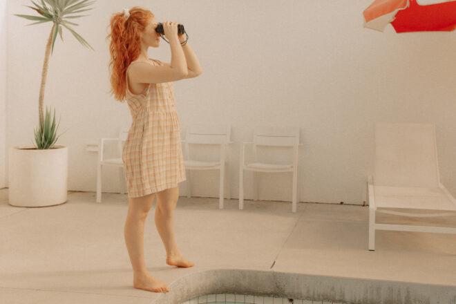 person wearing plaid cotton dress while using binoculars
