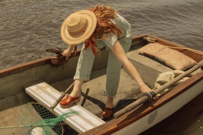 Person in green jumpsuit in a boat