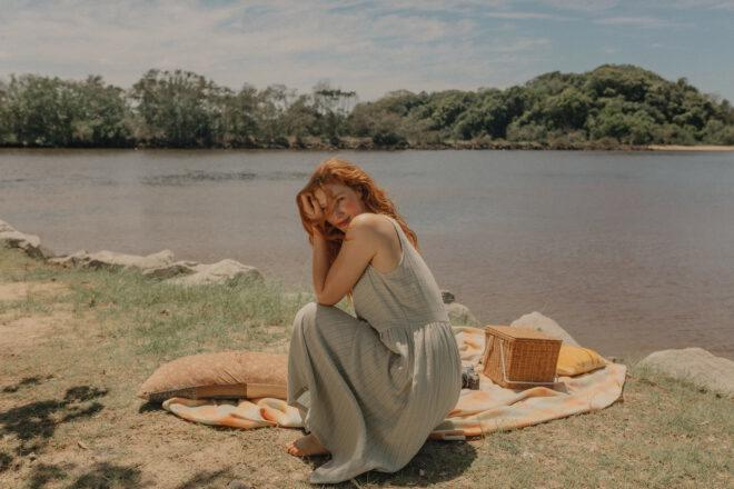 Person in cotton dress having a picnic by the lake