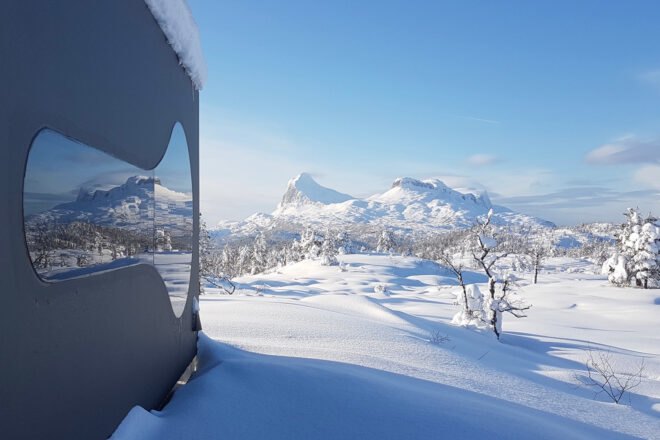 black cabin in a snowy landscape