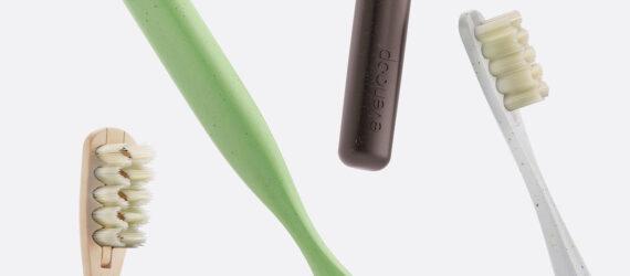 tan, white, black and green toothbrushes on white background