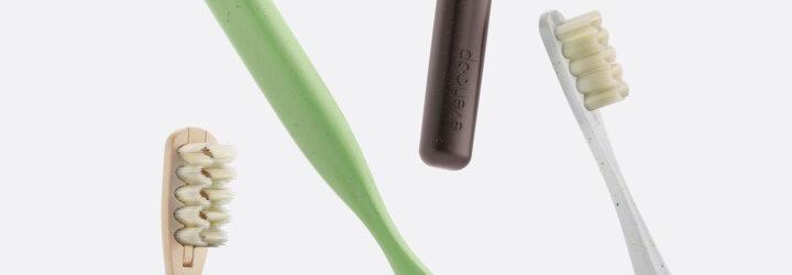 tan, white, black and green toothbrushes on white background
