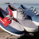 red, gray and blue boat shoes on a rock with water in the background
