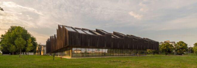 elongated timber building with many roofs