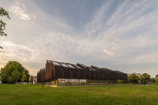 elongated timber building with many roofs