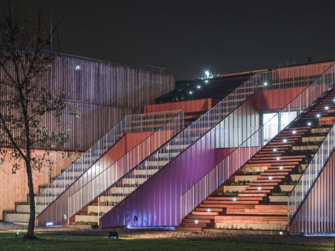 sideview of an outdoor stadium area with tall staircases attached to a building