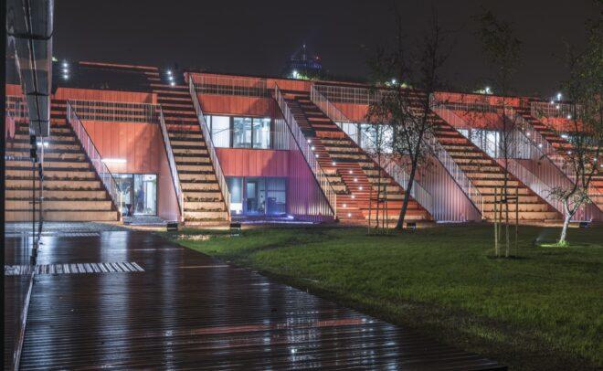 an outdoor stadium area with tall staircases attached to a building
