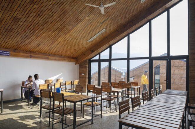 dining area with small wood tables and chairs and one wall of glass