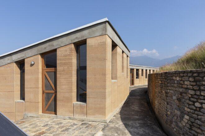 rammed earth building with tall, narrow windows