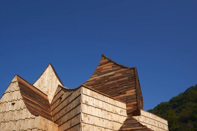 several sharply pitched roofs on wooden building