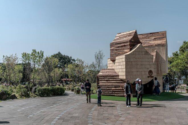 people standing around base of wooden building