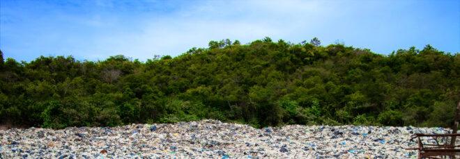 a landfill in front of green trees
