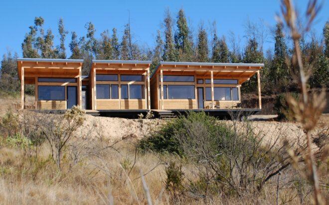 a rectangular house with windows atop a hill
