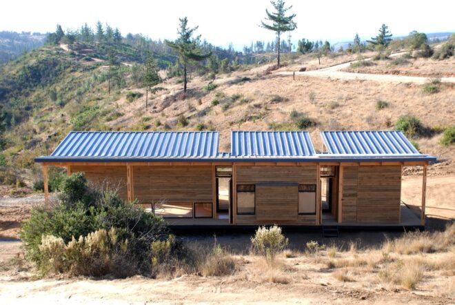 a rectangular house with solar panels on the roof and wood facade
