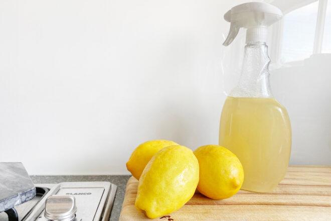 lemons near bottle of homemade vinegar and lemon cleaner