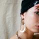 person wearing gold asymmetrical hoop earrings