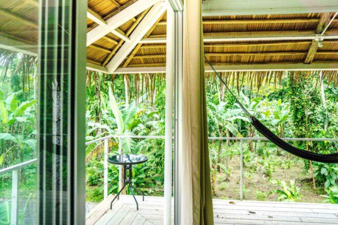 covered balcony with a hammock and small table