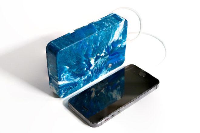 a blue and white marbled external charger connect to a smartphone