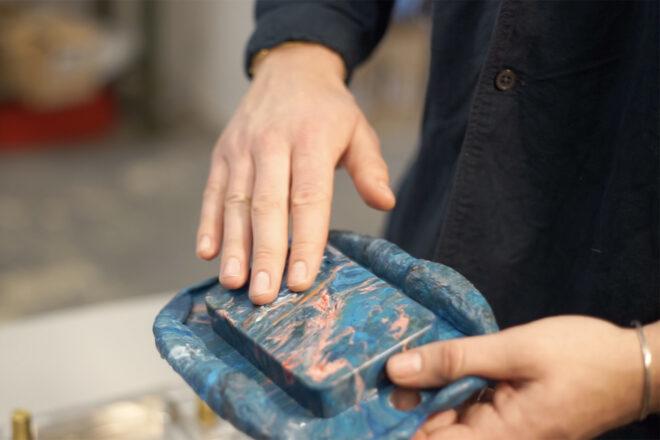 a pink and blue external charger being held in a person's hands