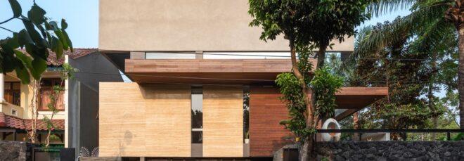 closeup of the front of the house, featuring a facade comprised of several different materials, including both dark and light colored woods