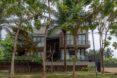 a multi-story home with trees in front of the facade