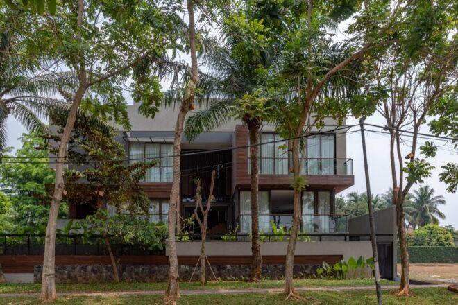 a multi-story home with trees in front of the facade