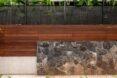 a wood and stone wall separating the home from greenery