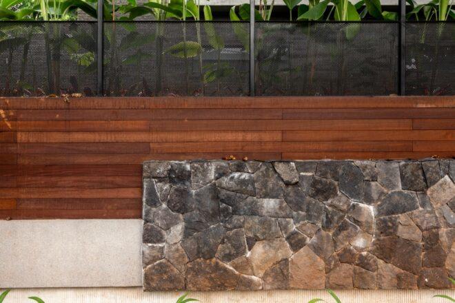 a wood and stone wall separating the home from greenery