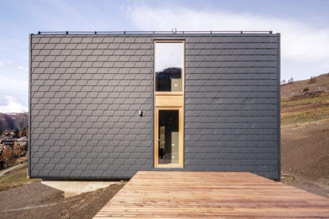 wood platform leading to dark gray home