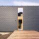 wood platform leading to dark gray home