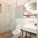 white toilet and sink near stand-up shower with glass wall