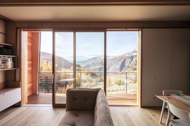 beige sofa by sliding glass door revealing mountainous views