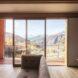 beige sofa by sliding glass door revealing mountainous views