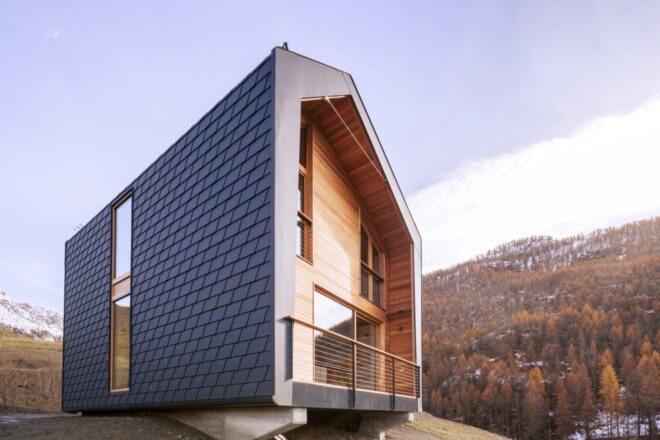 dark gray and wood home on a hill