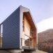 dark gray and wood home on a hill
