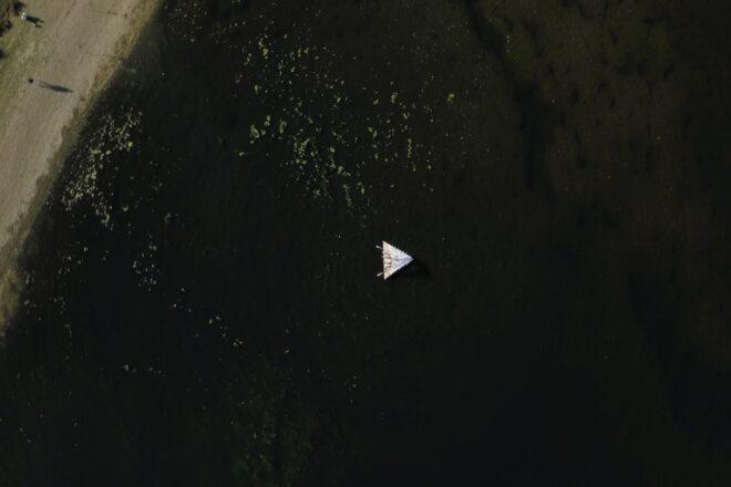 aerial shot of tiny raft in the water