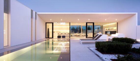 long white villa with a long narrow swimming pool