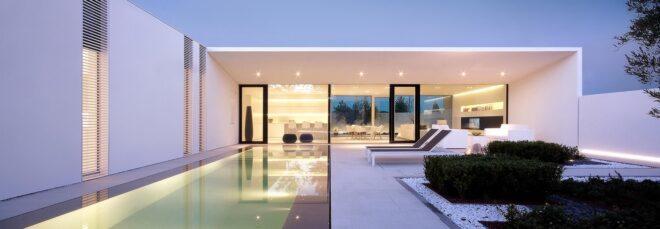 long white villa with a long narrow swimming pool