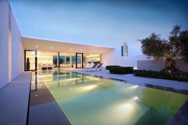 large swimming pool and lounge chairs outside a white villa