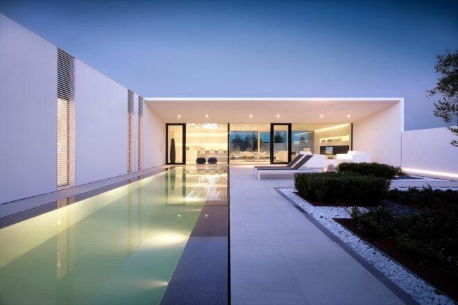 long white villa with a long narrow swimming pool