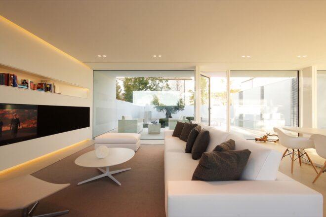 white sofa with gray pillows and a white coffee table